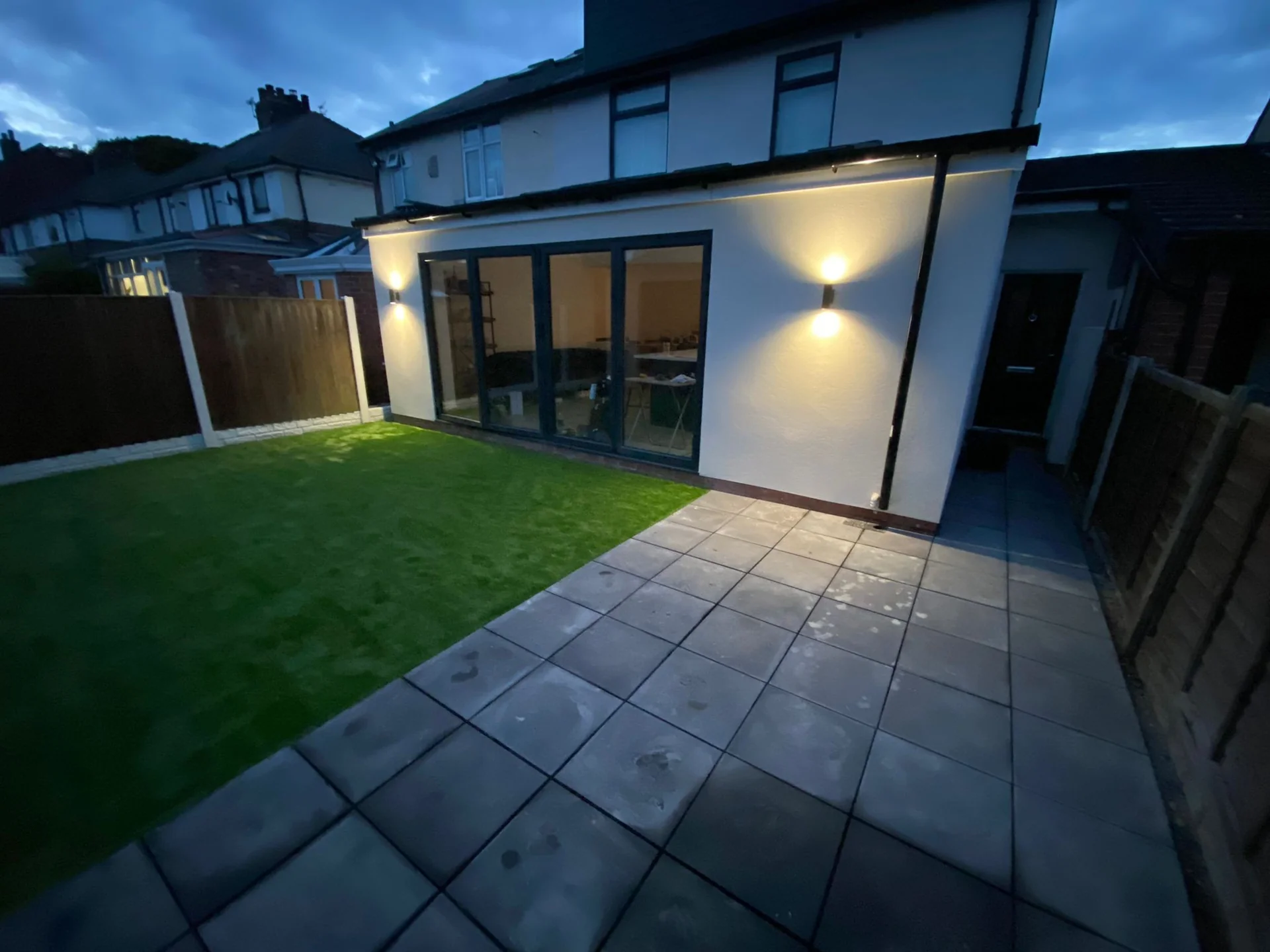 Rendered rear elevation, garden and glazed doors in the evening