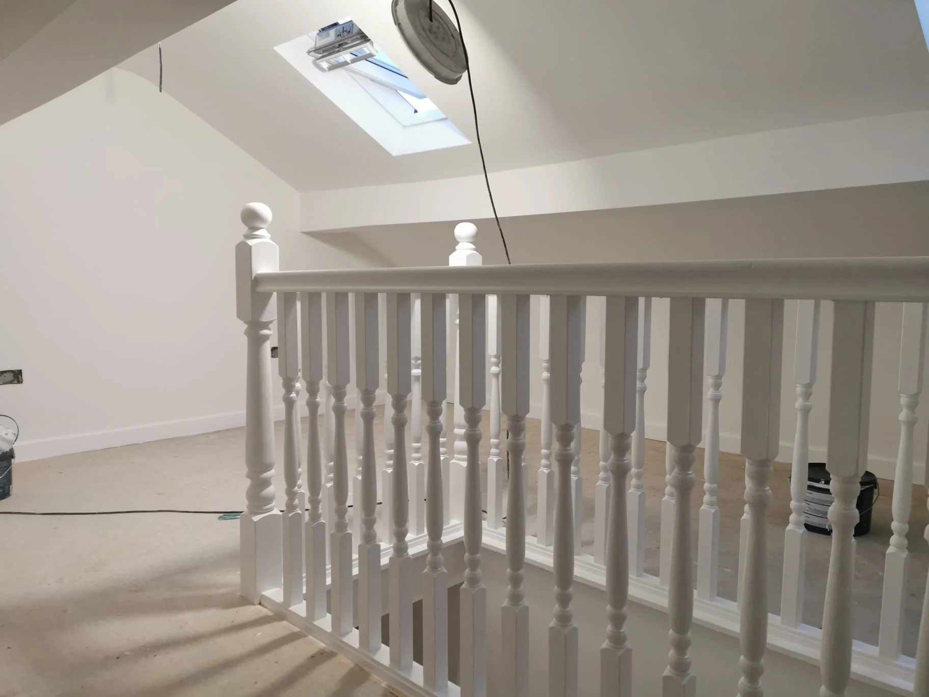 Finished loft stair balustrade beneath a sloping ceiling
